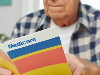 A senior citizen looking through a medicare booklet, depicting the learning process of the program